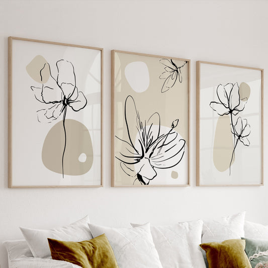 Floral line art prints in beige and black displayed as a trio in light wood frames