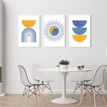 Abstract blue and mustard boho prints in white frames above a round dining table setup