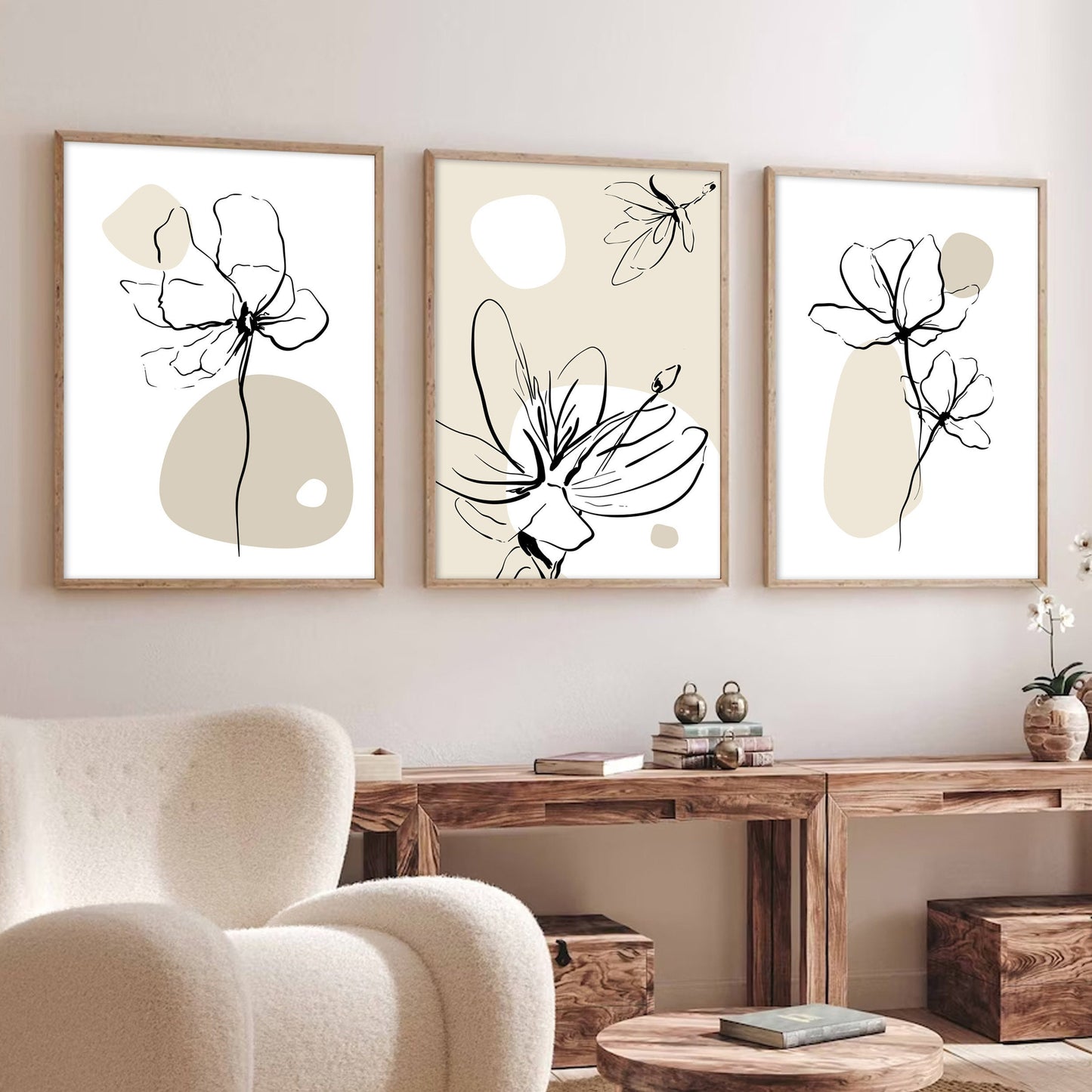 Trio of minimalist beige floral line art prints in wood frames above a wooden console
