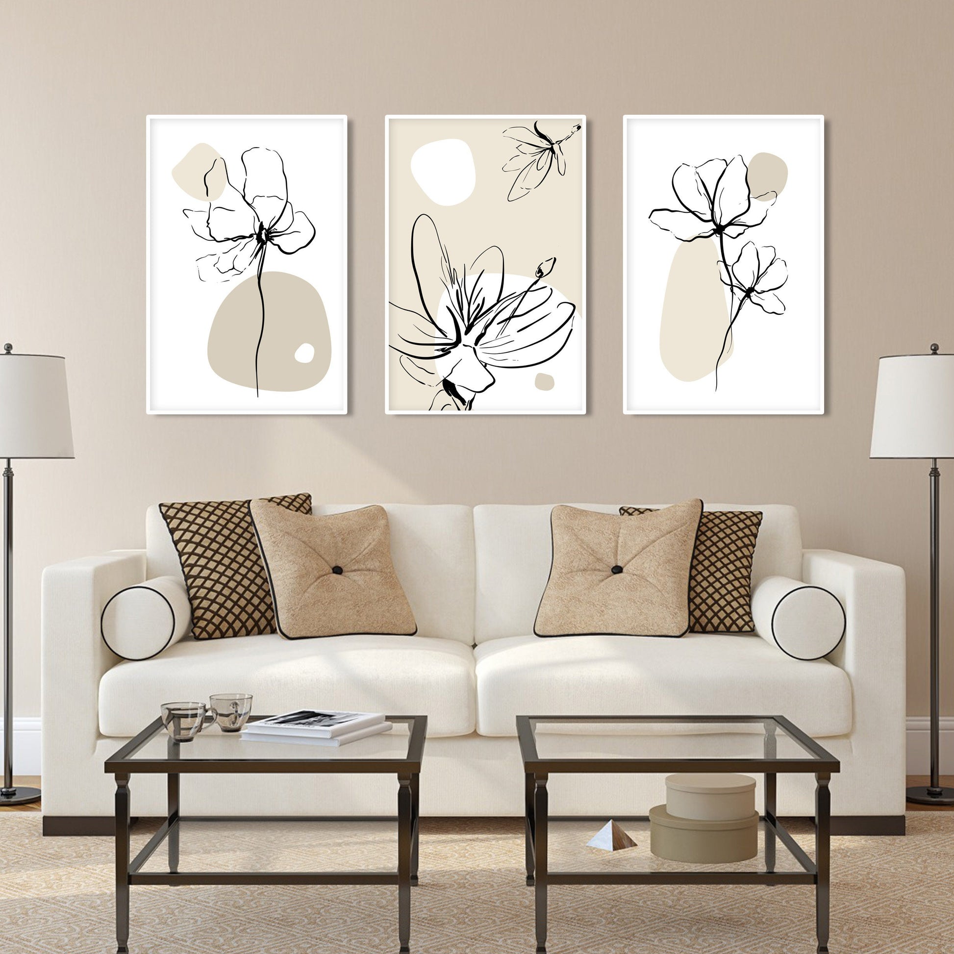 Boho floral line art trio in white frames arranged above a beige sofa