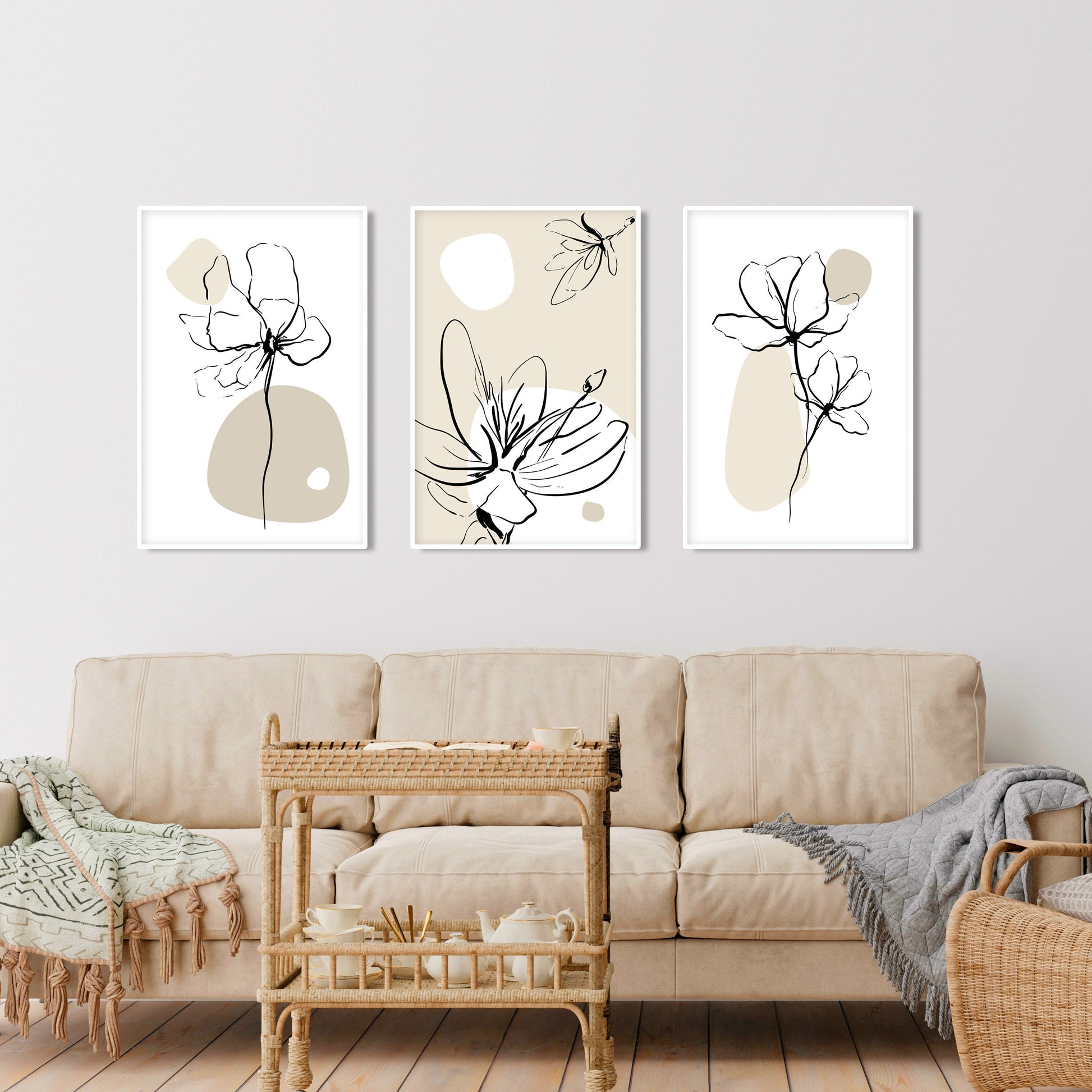 Three framed boho floral line art prints with neutral beige accents above a cream sofa