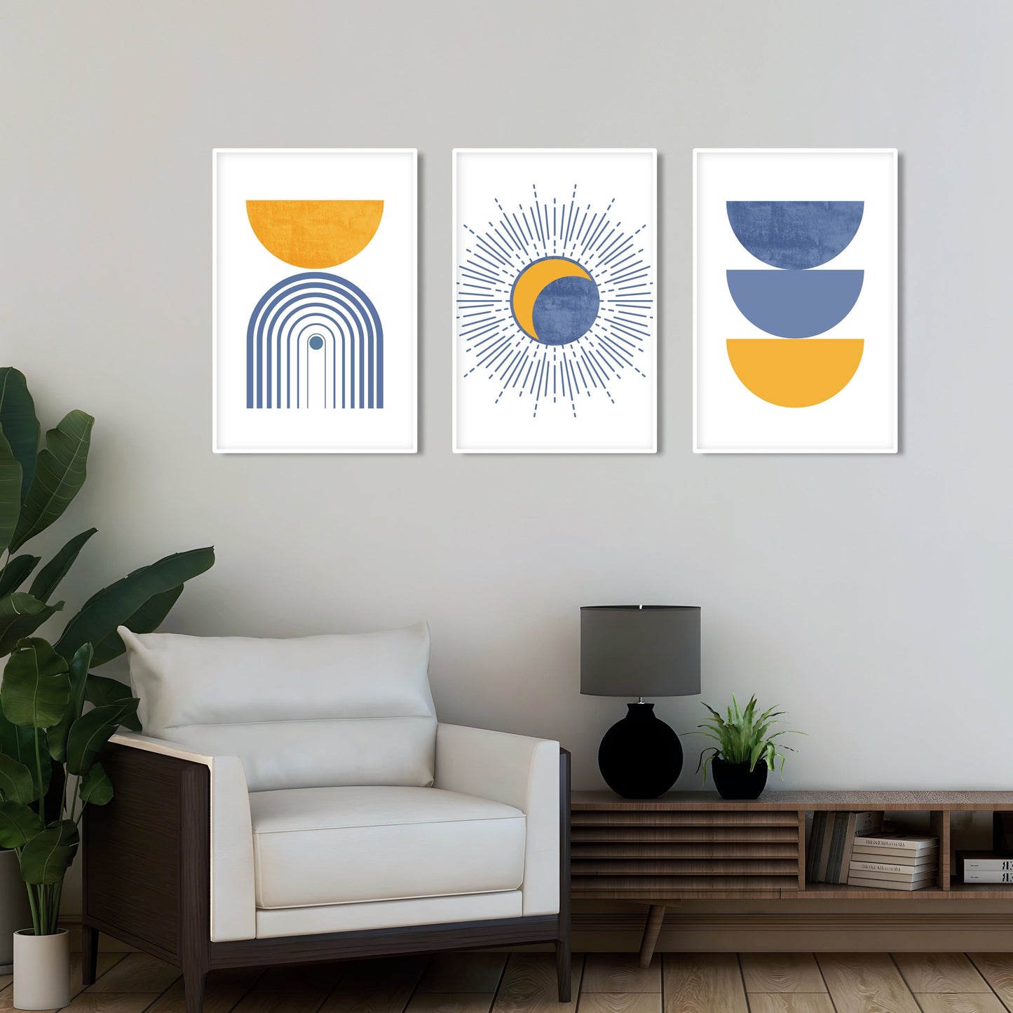 Three framed geometric boho prints in blue and mustard arranged above a lounge chair.