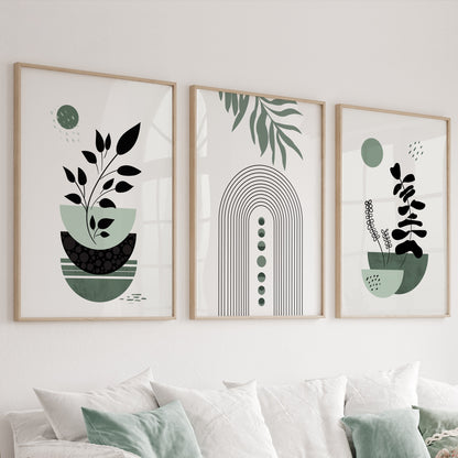 Three sage green minimalist boho prints in wood frames displayed above a sofa