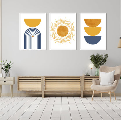 Three framed abstract boho prints in blue and mustard above a wooden console table