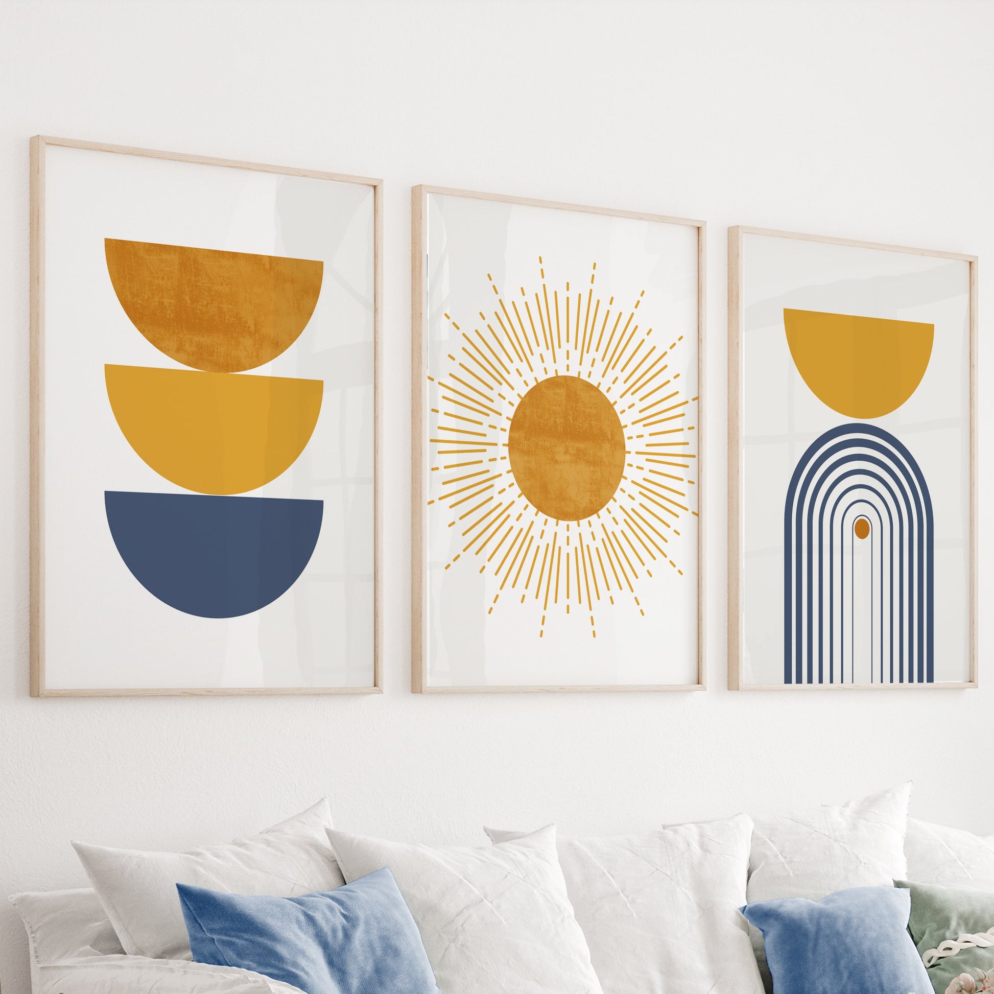 Three large framed abstract boho prints displayed as a gallery set above a sofa