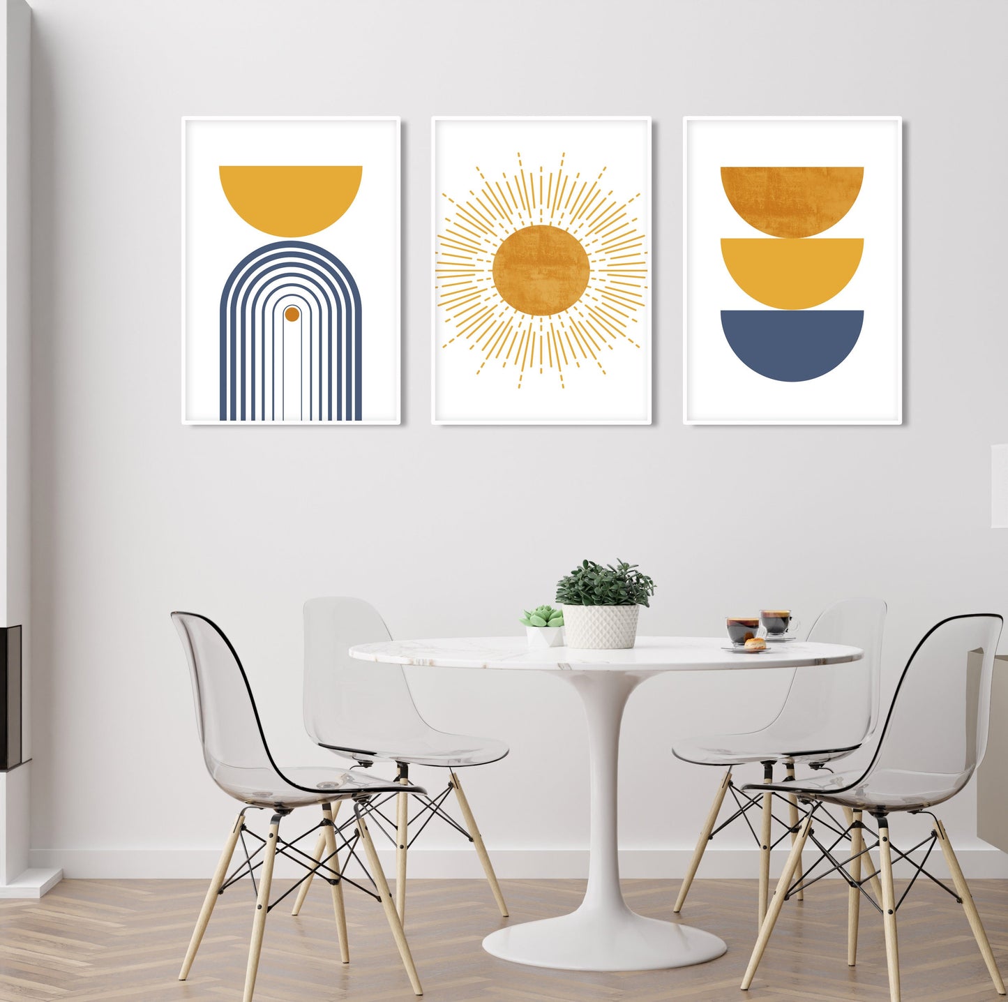 Three framed geometric abstract prints in blue and mustard above a round dining table