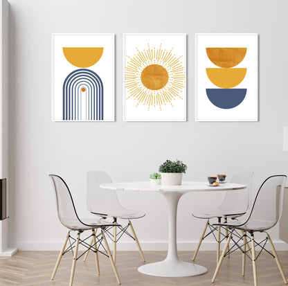 Three framed geometric abstract prints in blue and mustard above a round dining table