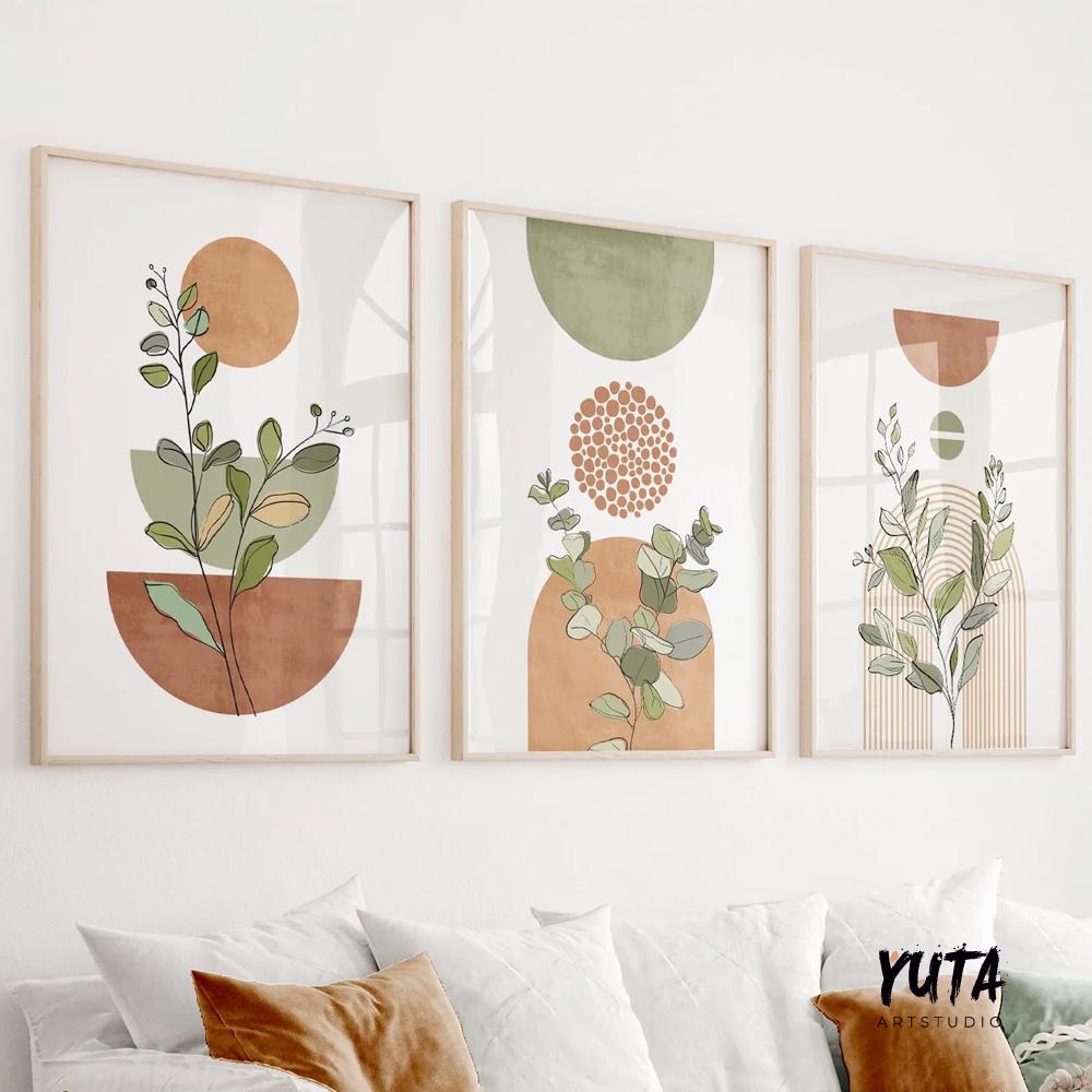 Trio of framed botanical prints with terracotta and sage abstract shapes above a white sofa