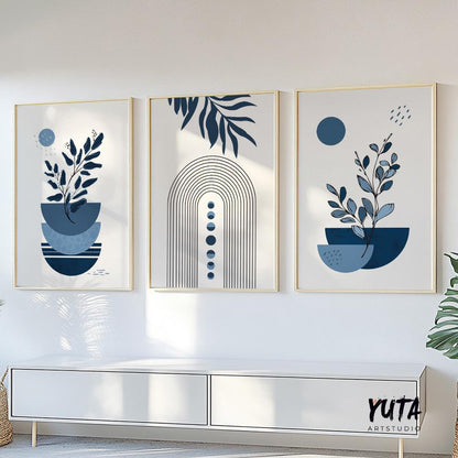 Abstract navy blue botanical and arch prints in gold frames above a modern white console