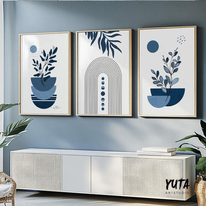 Trio of framed navy blue abstract botanical prints arranged above a white sideboard