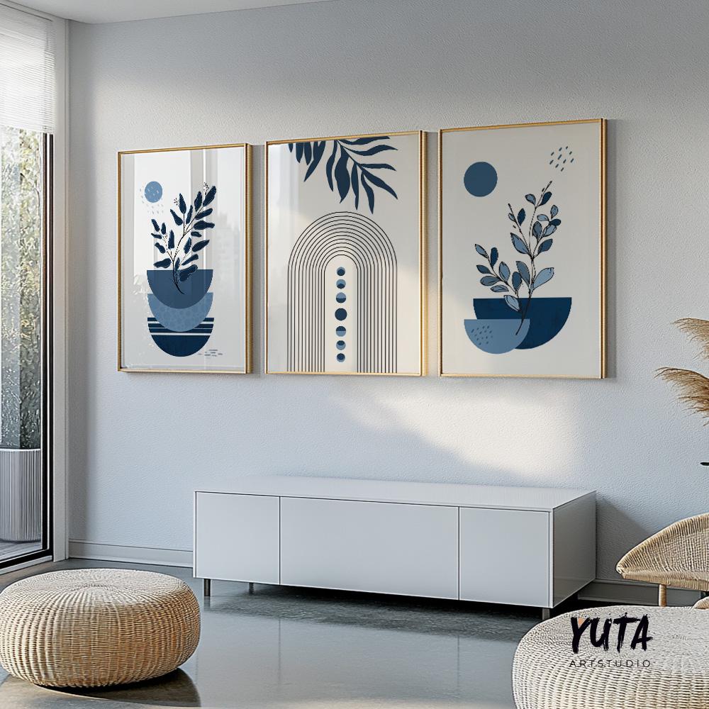 Three navy blue boho art prints in gold frames displayed above a low white cabinet in soft daylight