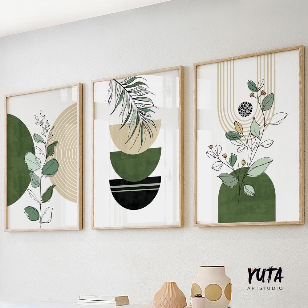 Boho green and black abstract botanical art trio in light wood frames above ceramics and books