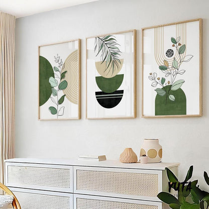 Three framed abstract green and black botanical prints in a vertical arrangement above a white sideboard.