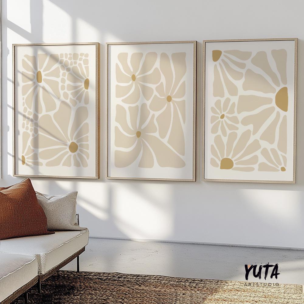 Set of three framed beige abstract floral prints displayed above a modern sofa.