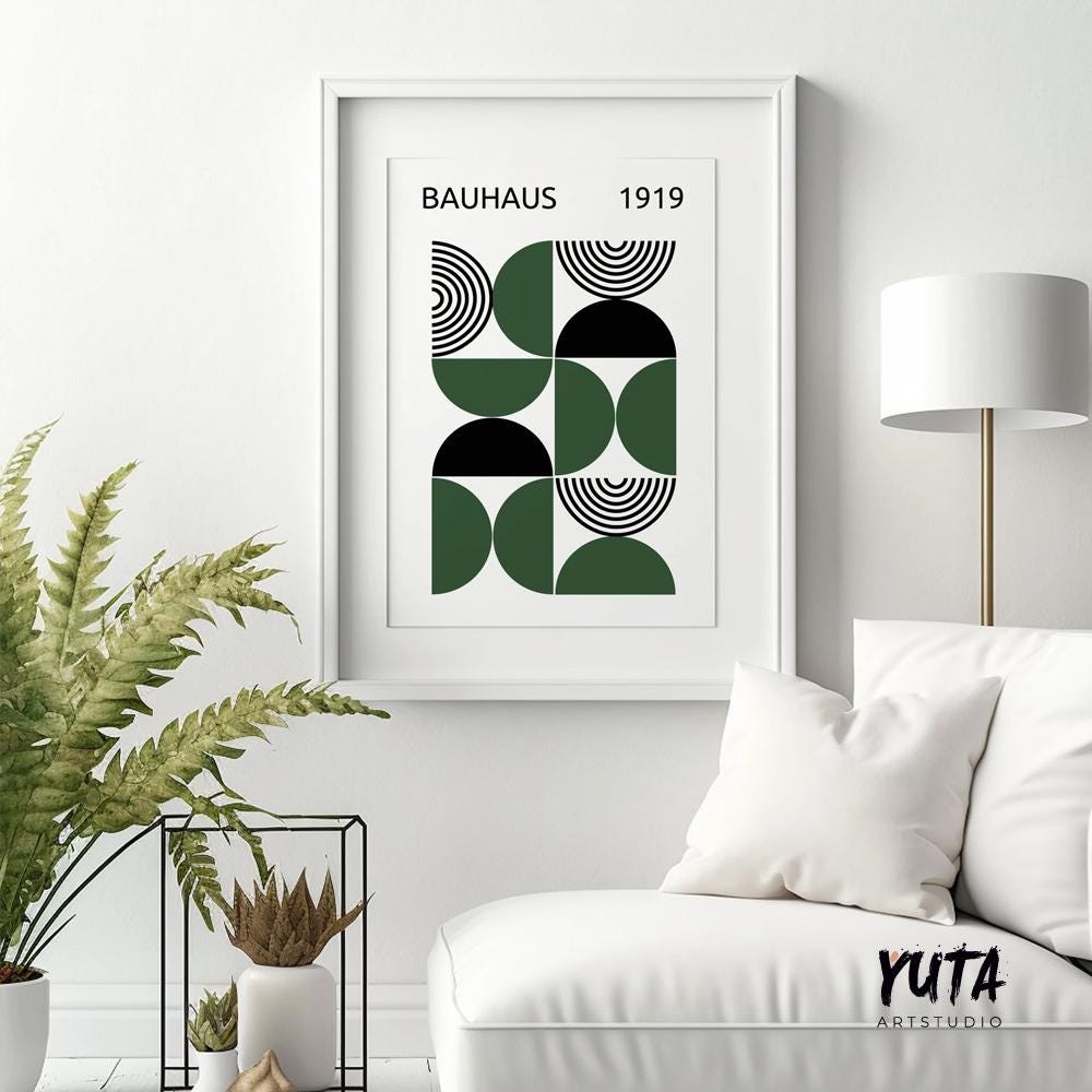 Geometric Bauhaus-inspired art print in black and dark green, framed above a white chair
