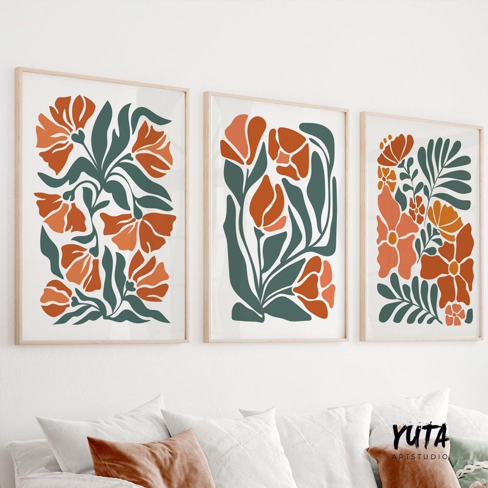 Three minimalist botanical prints in natural wood frames arranged above a white console