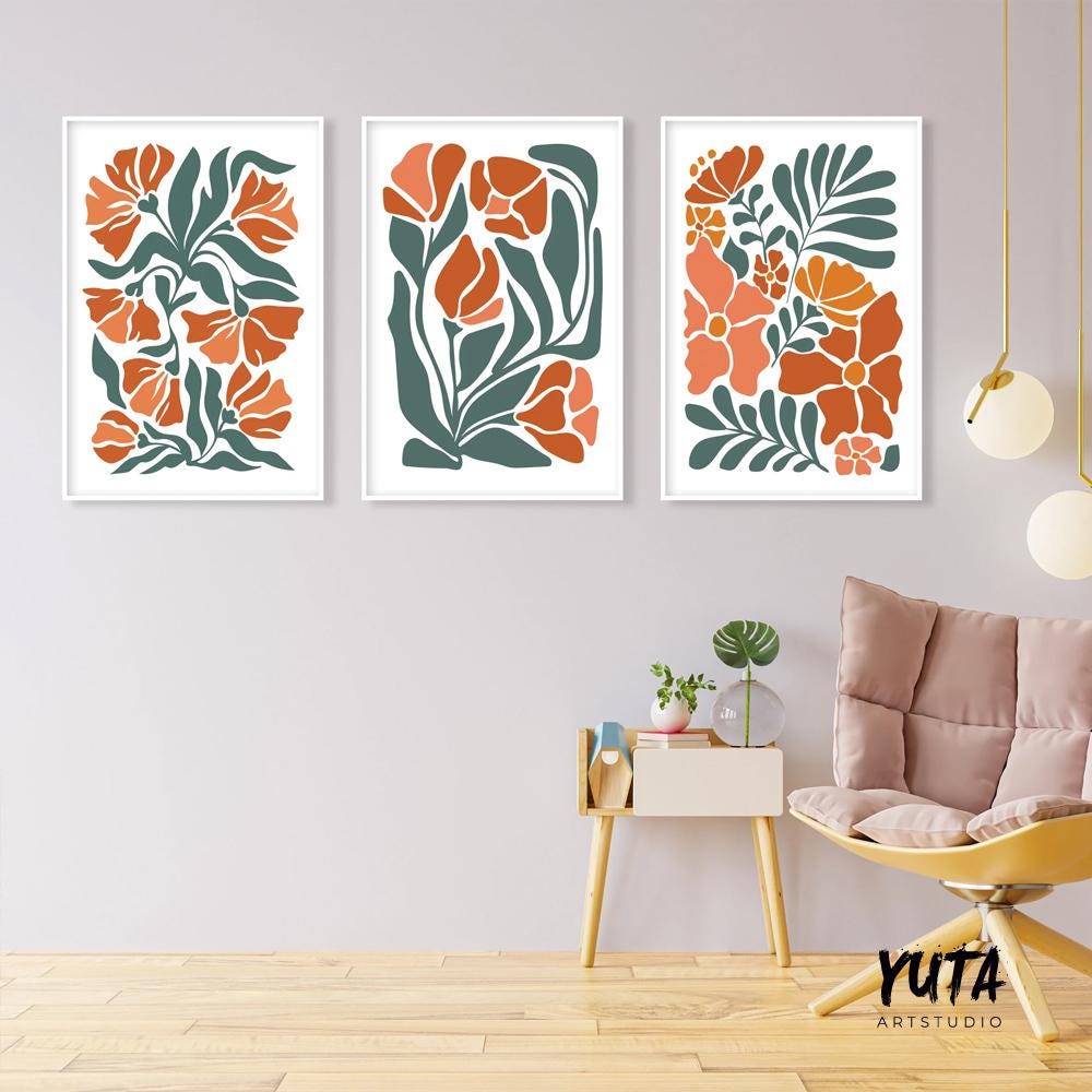Trio of framed boho floral prints in terracotta tones above a modern accent chair