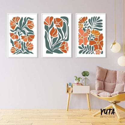 Trio of framed boho floral prints in terracotta tones above a modern accent chair