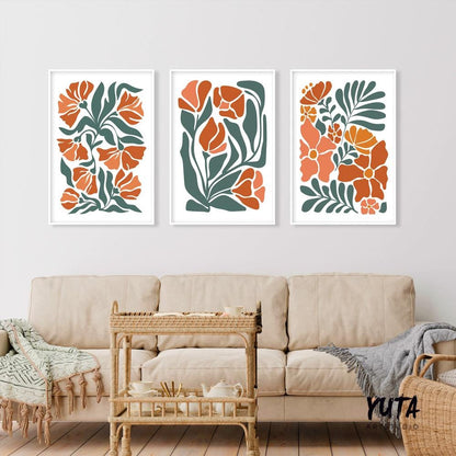 Three framed boho floral prints in light terracotta and green, arranged above a beige sofa