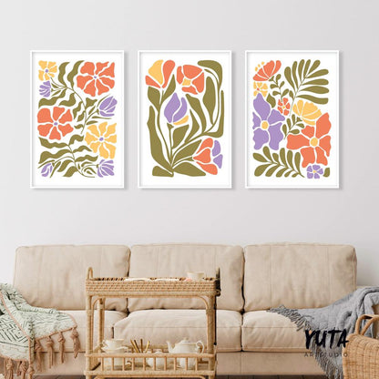 Trio of framed Matisse-inspired floral prints above a beige sofa with woven tea cart and books