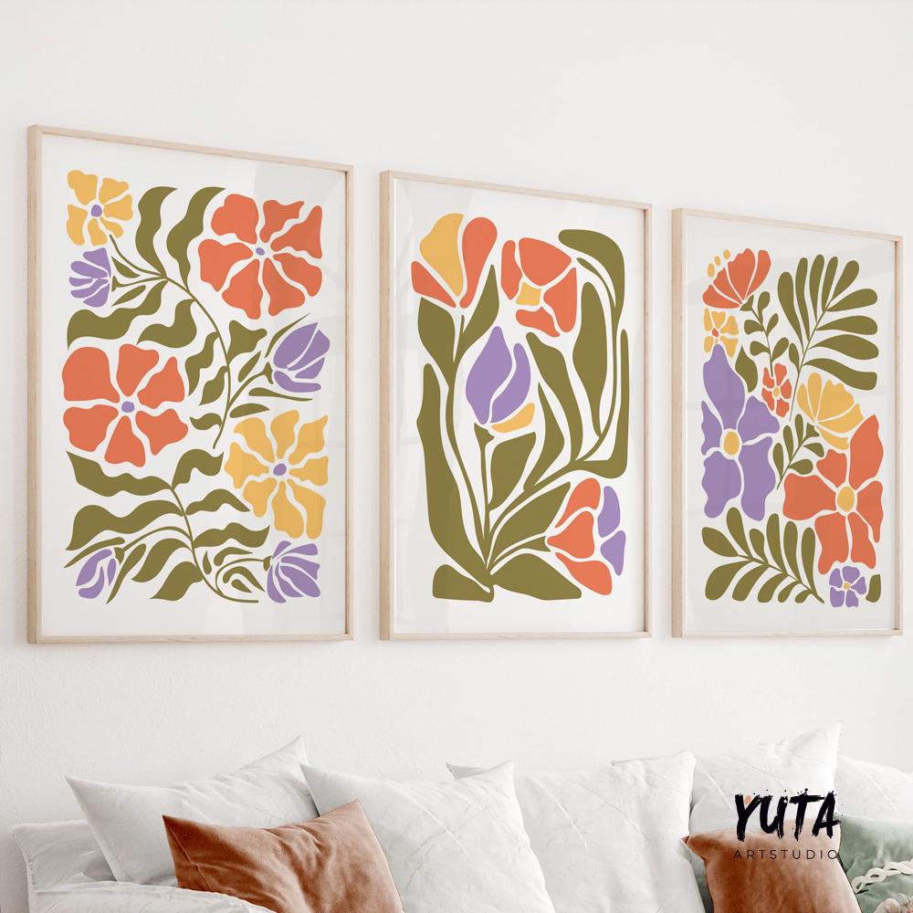 Three framed Matisse-inspired floral prints in bold colors arranged above a white sofa