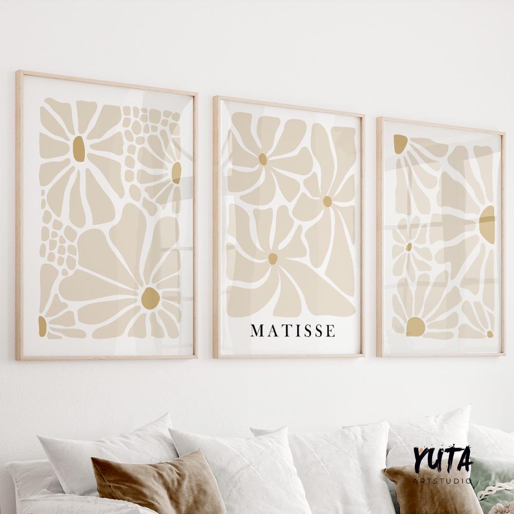 Set of three minimalist Matisse floral prints in light wood frames hung above a sofa