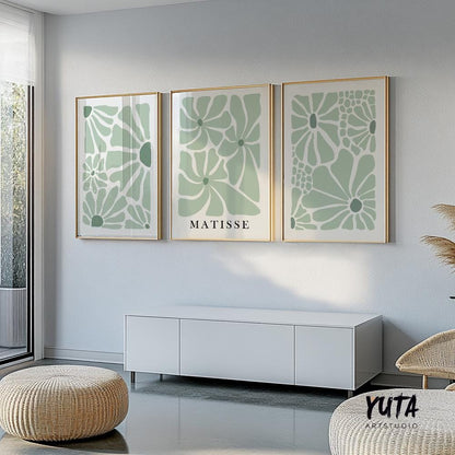 Sage green Matisse-inspired floral prints in gold frames arranged above a white console