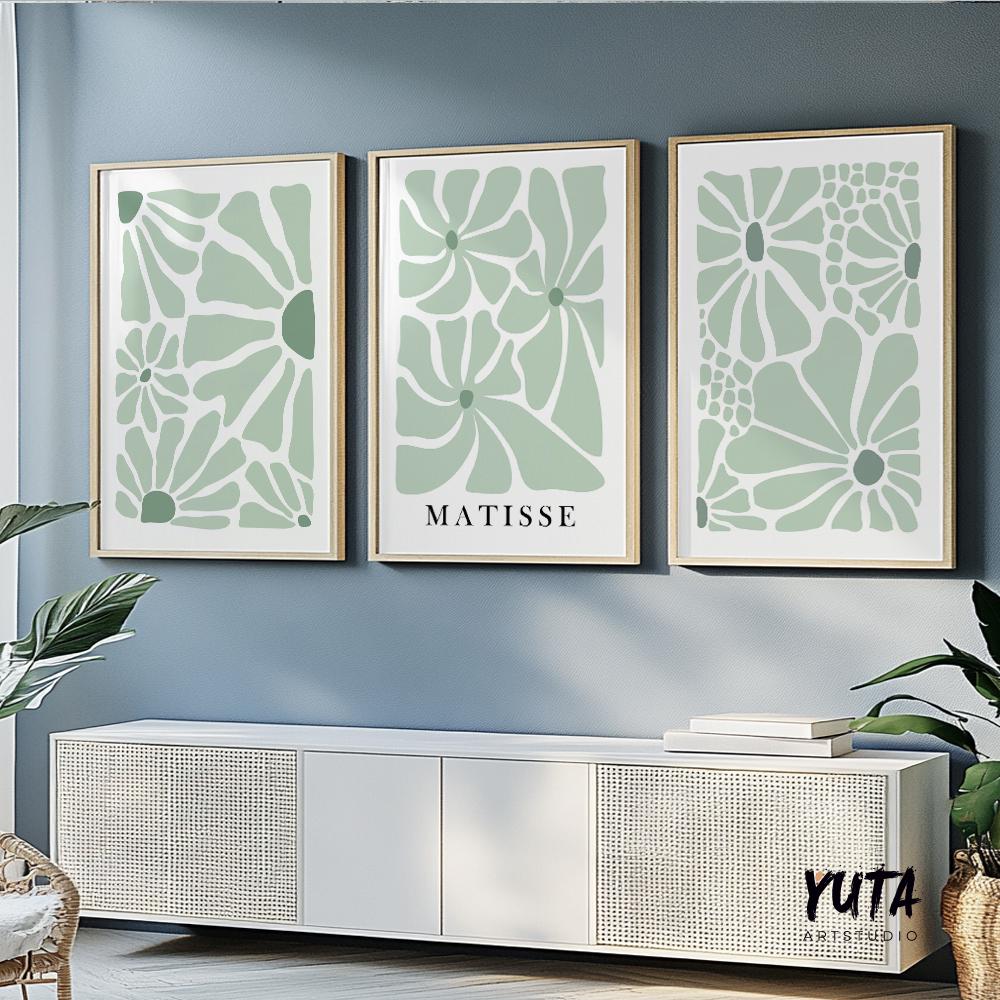 Abstract sage green floral prints in minimalist mid century style, framed as a trio above a white sideboard