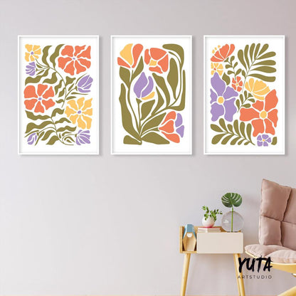 Three framed Matisse-inspired floral prints arranged as a gallery wall above a small table and chair.