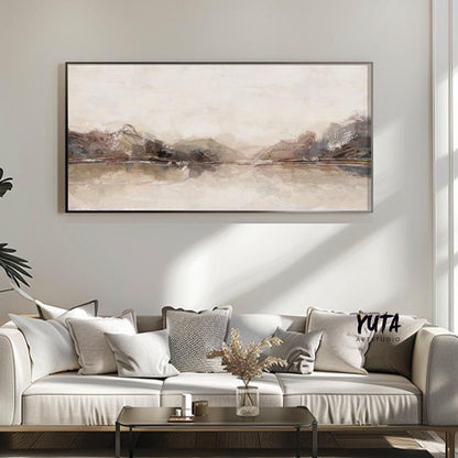 Neutral panoramic abstract artwork in a slim frame centered above a light sofa arrangement