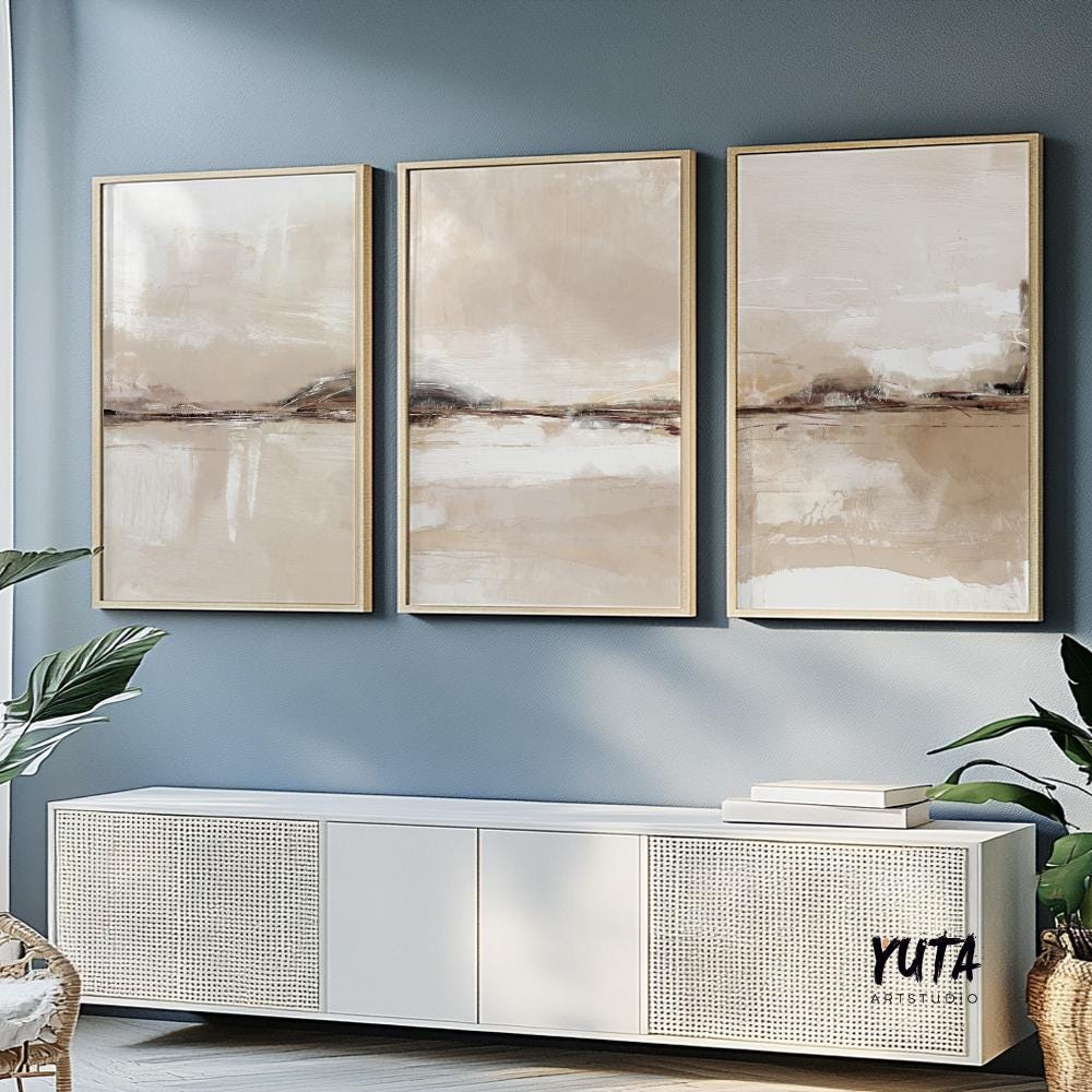 Neutral abstract landscapes in beige tones, framed as a triptych above a white console