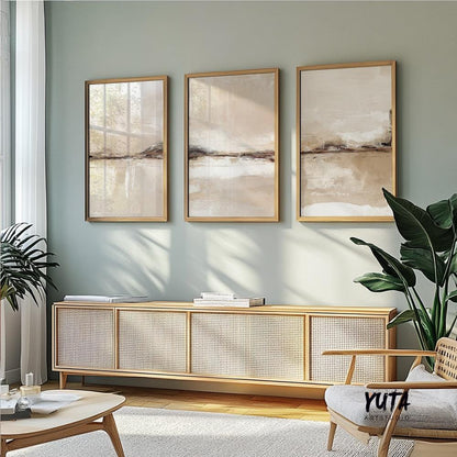 Set of three framed neutral abstract prints displayed above a sideboard in sunlight