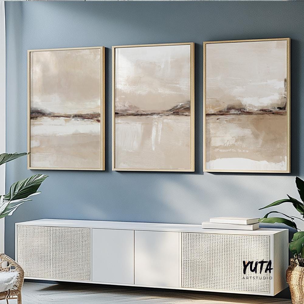 Neutral abstract triptych with soft beige tones in light wood frames above a modern sofa