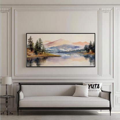 Framed pastel mountain landscape print centered above a light sofa in natural daylight