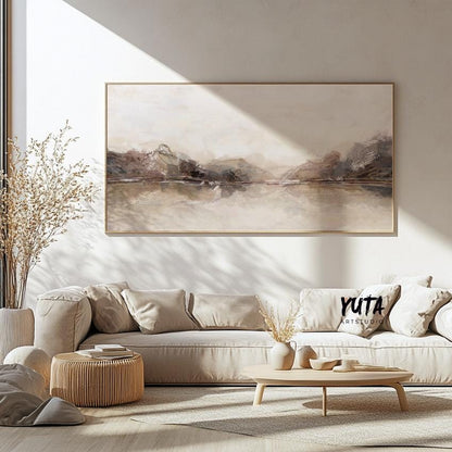 Neutral panoramic abstract print in soft beige tones, framed and centered above a cream sofa