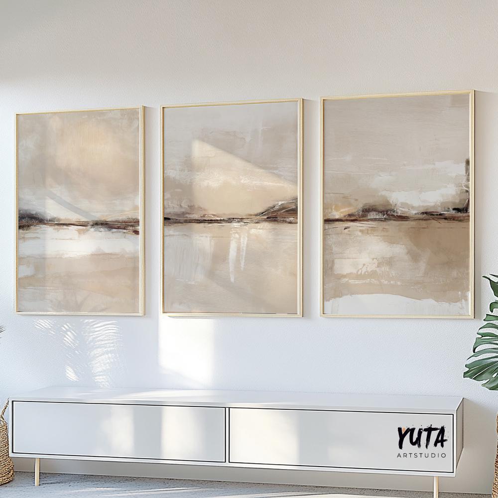 Three minimalist abstract landscape prints in light wood frames arranged above a white console
