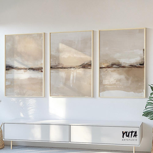 Three minimalist abstract landscape prints in light wood frames arranged above a white console