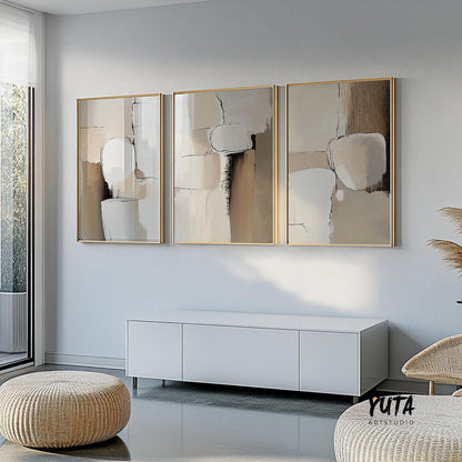 Neutral abstract triptych in gold frames arranged symmetrically above a white console