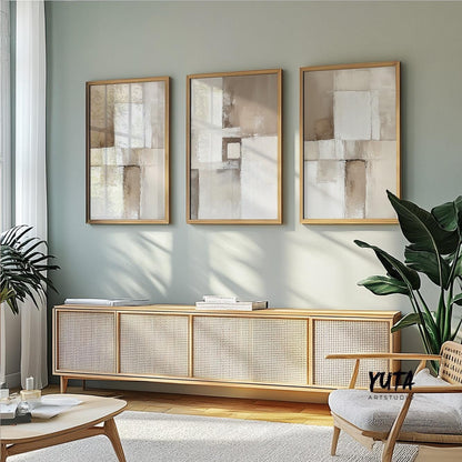 Three framed neutral abstract prints arranged above a sideboard in soft daylight