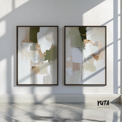Abstract pastel olive and beige brushstroke prints in dark frames on a sunlit white wall