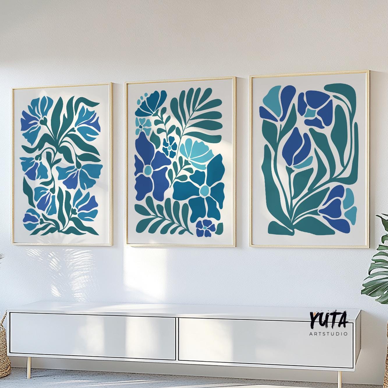 Bold blue botanical prints in a mid century style, framed as a trio above a white console
