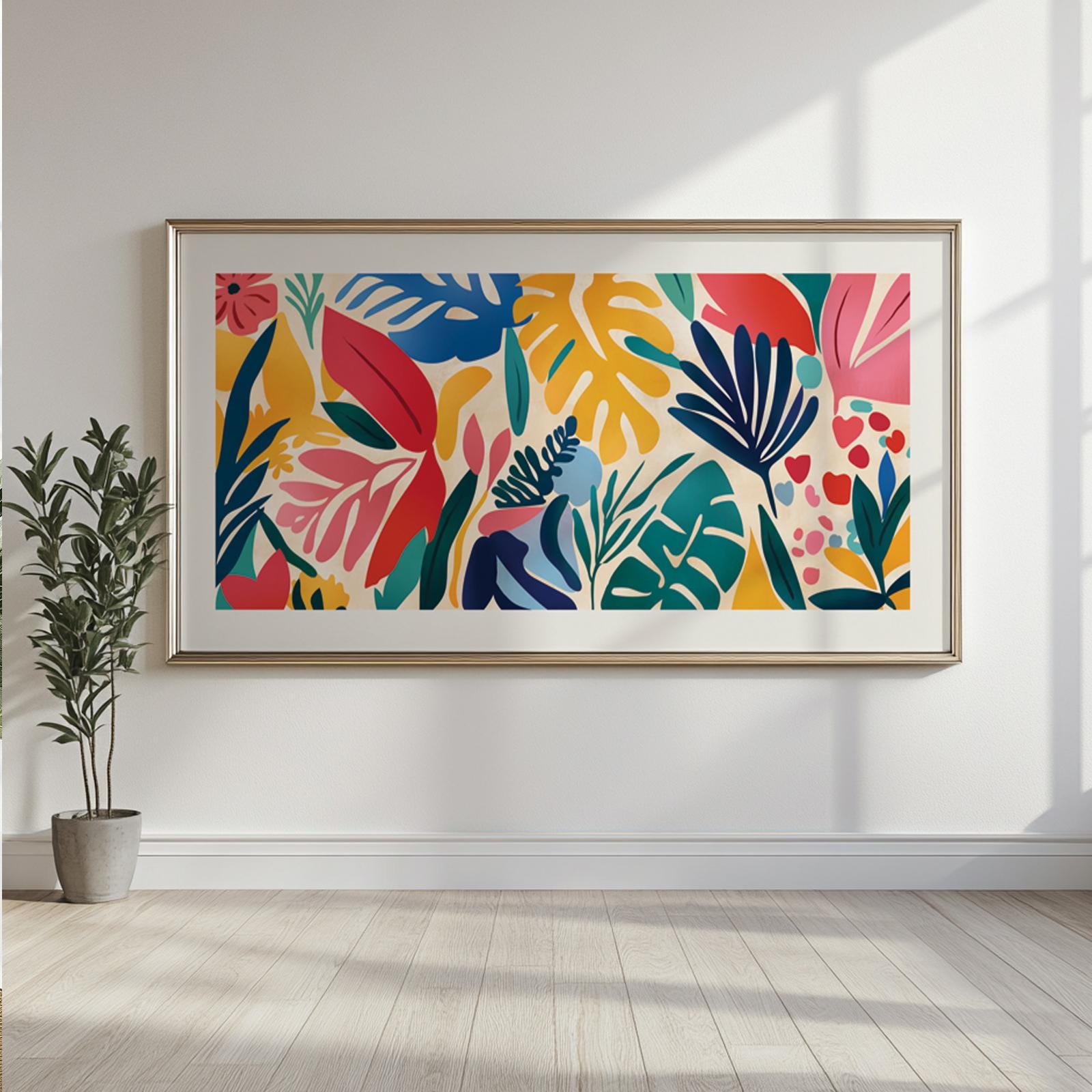 Framed Matisse-style tropical leaves print hanging above a potted plant on a sunlit wall