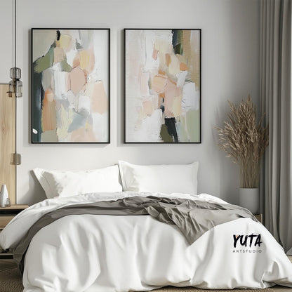 Pair of abstract pastel brushstroke prints in black frames hung above a bed