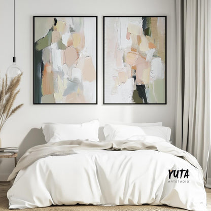 Abstract pastel brush stroke prints in black frames displayed above a bed with neutral bedding