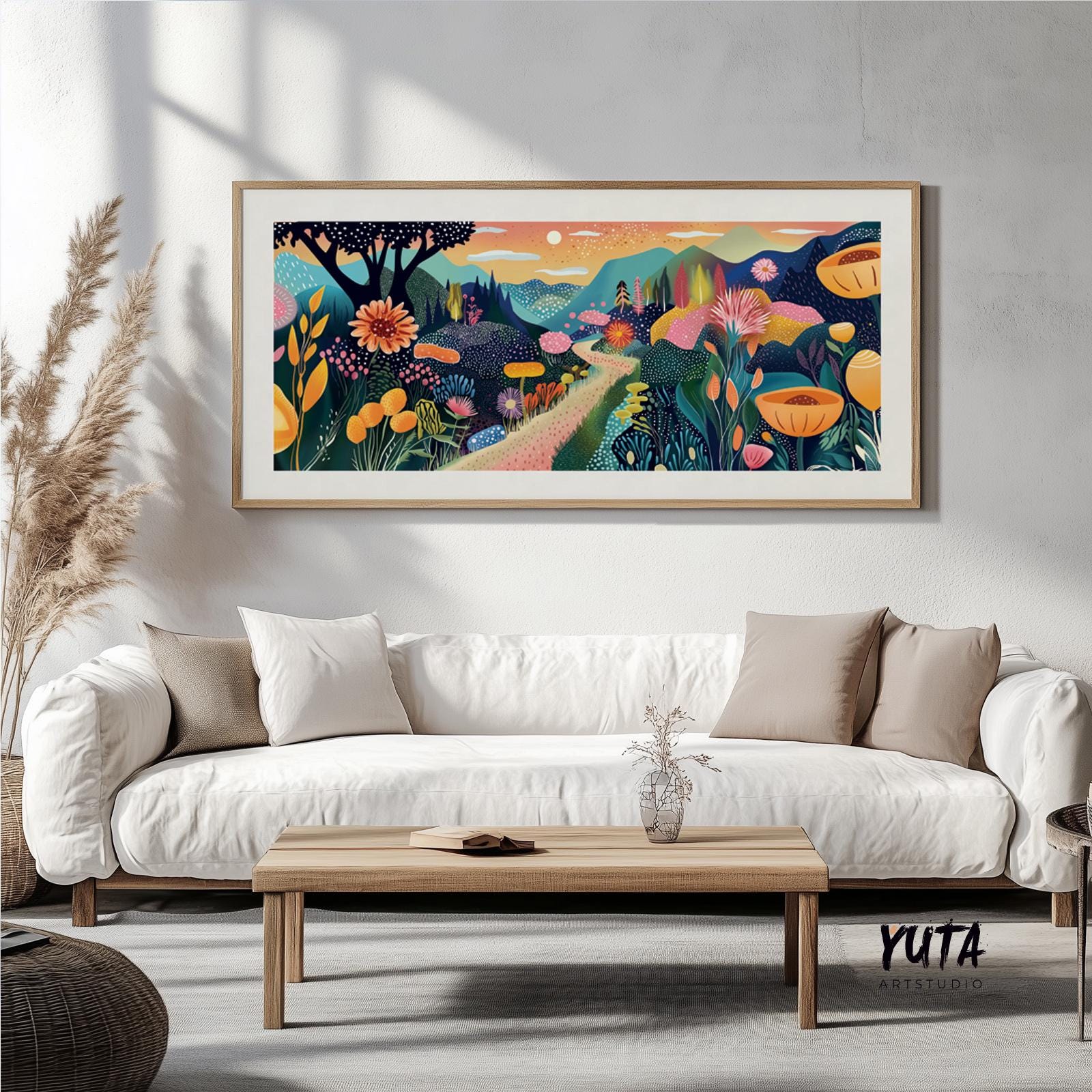 Vibrant botanical landscape artwork in a light wood frame displayed above a white sofa