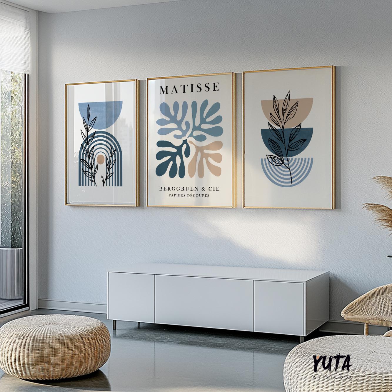 Three framed abstract blue and beige prints arranged in a horizontal gallery above a white cabinet.