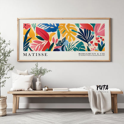 Framed Matisse print with colorful tropical leaves hangs above a minimalist wood bench