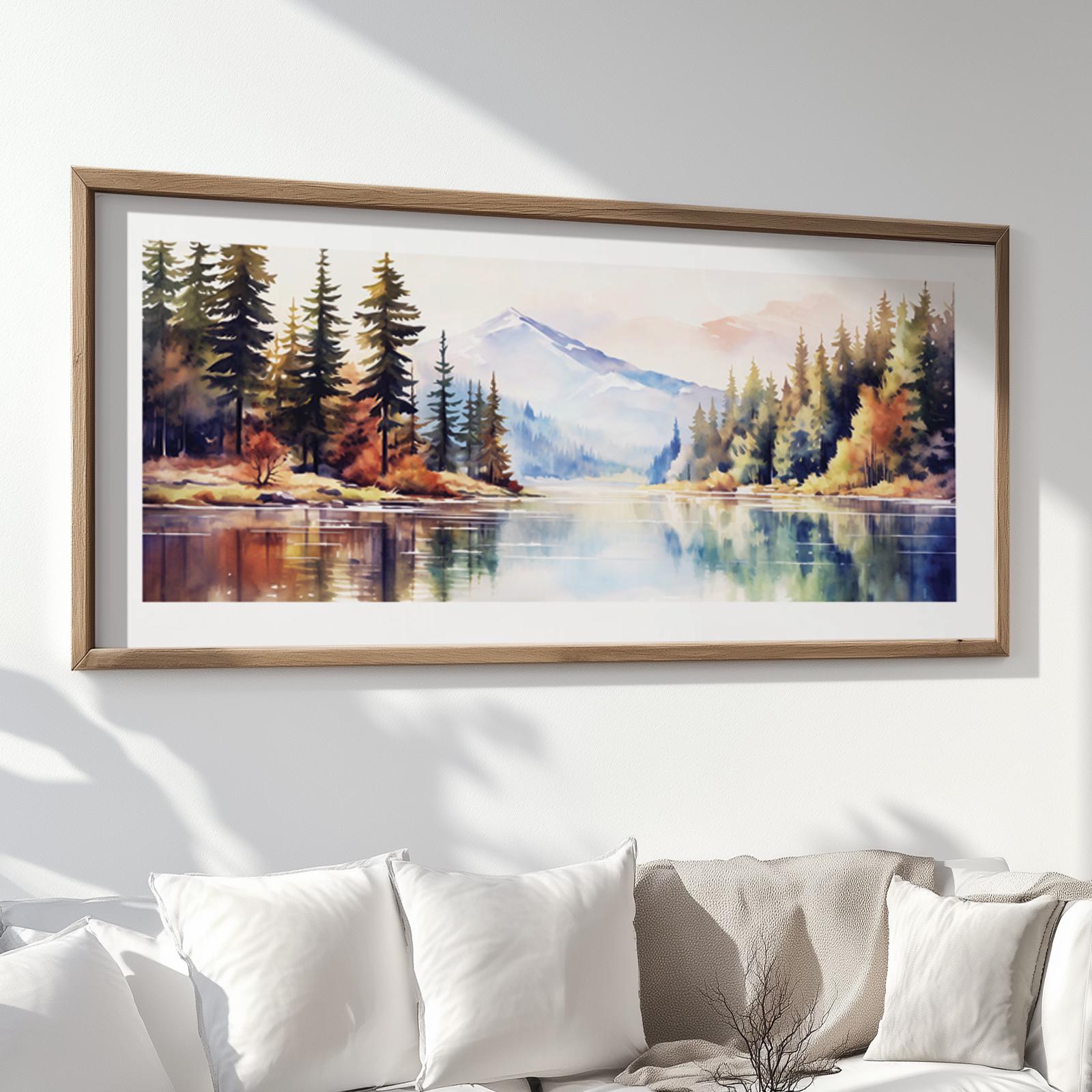 Watercolor-style panoramic mountain artwork in a natural wood frame above a white sofa
