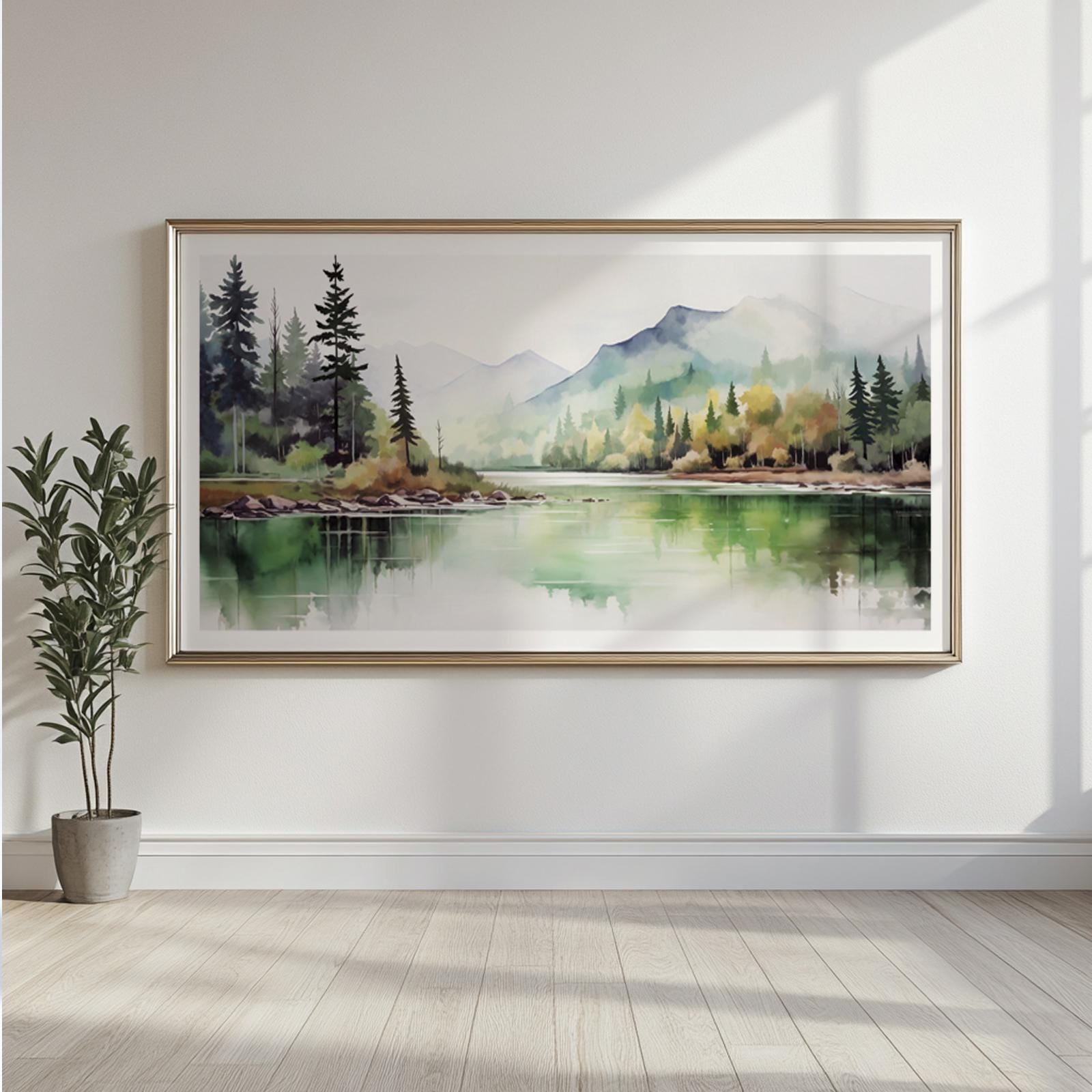 Framed watercolor landscape with pine trees and misty mountains above a potted plant.