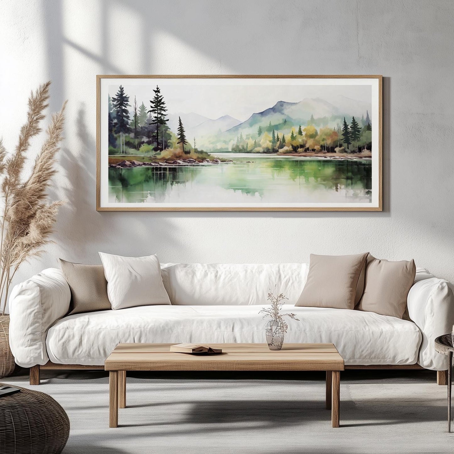 Framed minimalist landscape print centered above a white sofa in a bright room